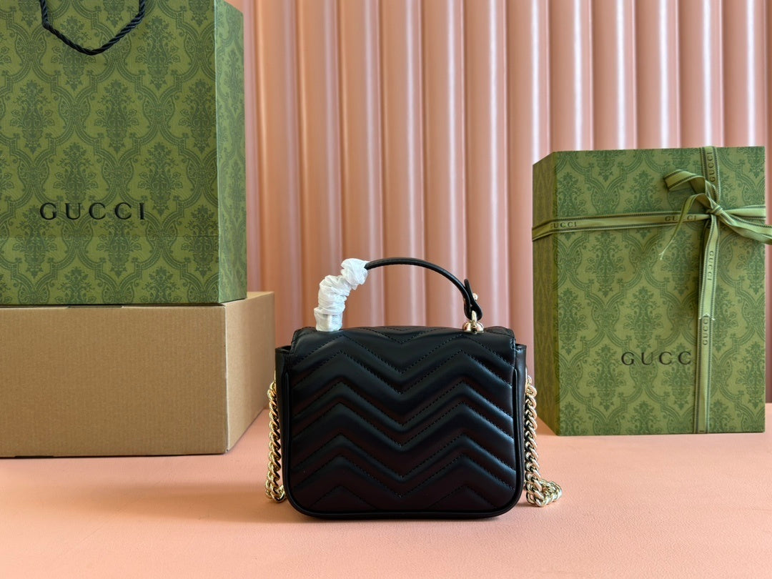 Gucci GG Marmont mini top handle bag in black quilted chevron leather.