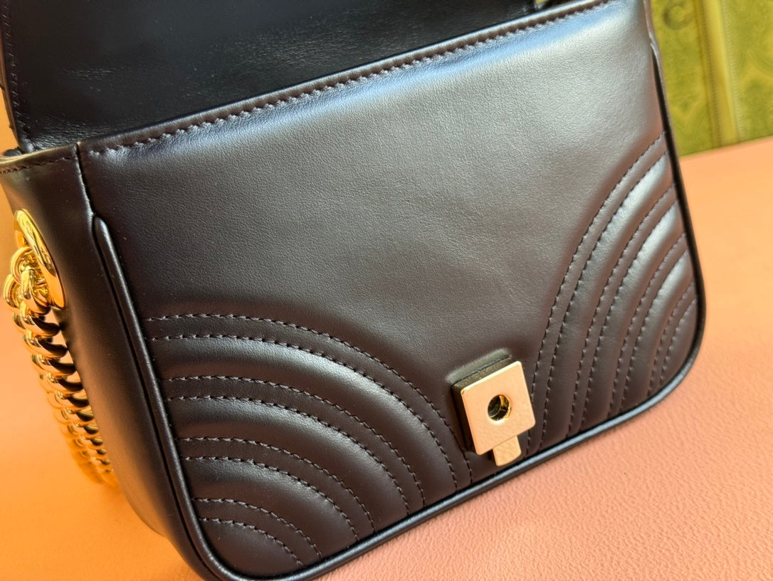 Gucci GG Marmont mini top handle bag in black quilted chevron leather.