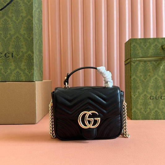 Gucci GG Marmont mini top handle bag in black quilted chevron leather.