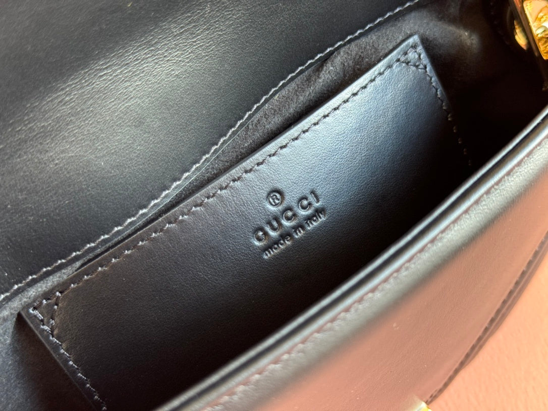 Gucci GG Marmont mini top handle bag in black quilted chevron leather.