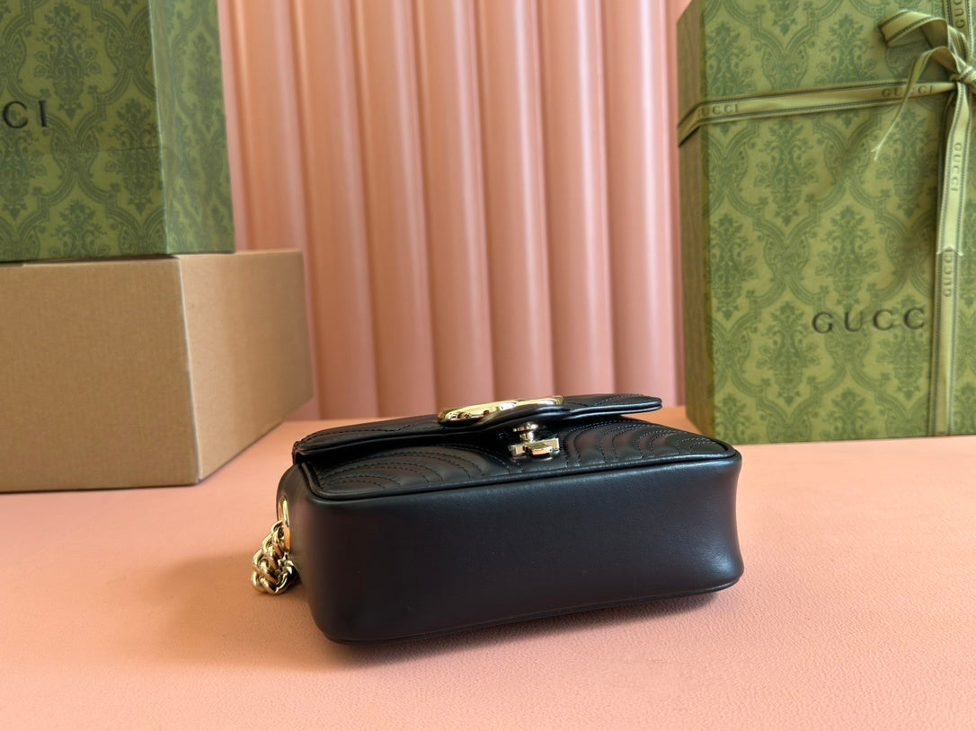 Gucci GG Marmont mini top handle bag in black quilted chevron leather.