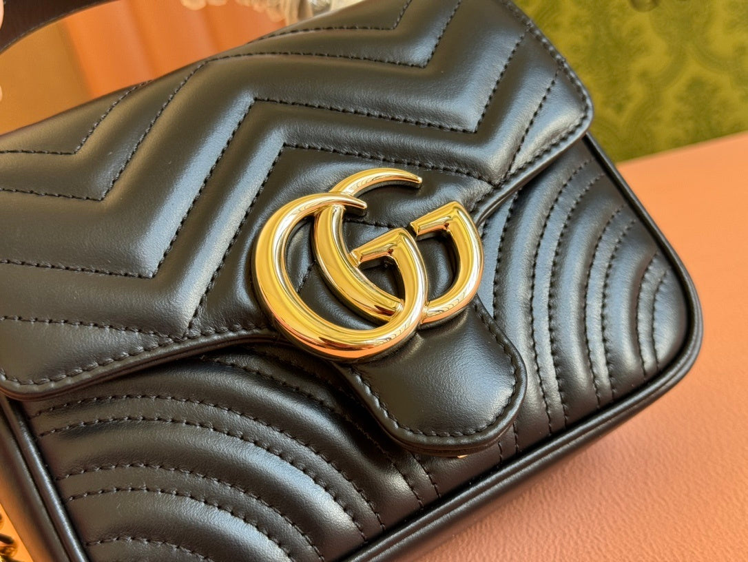 Gucci GG Marmont mini top handle bag in black quilted chevron leather.