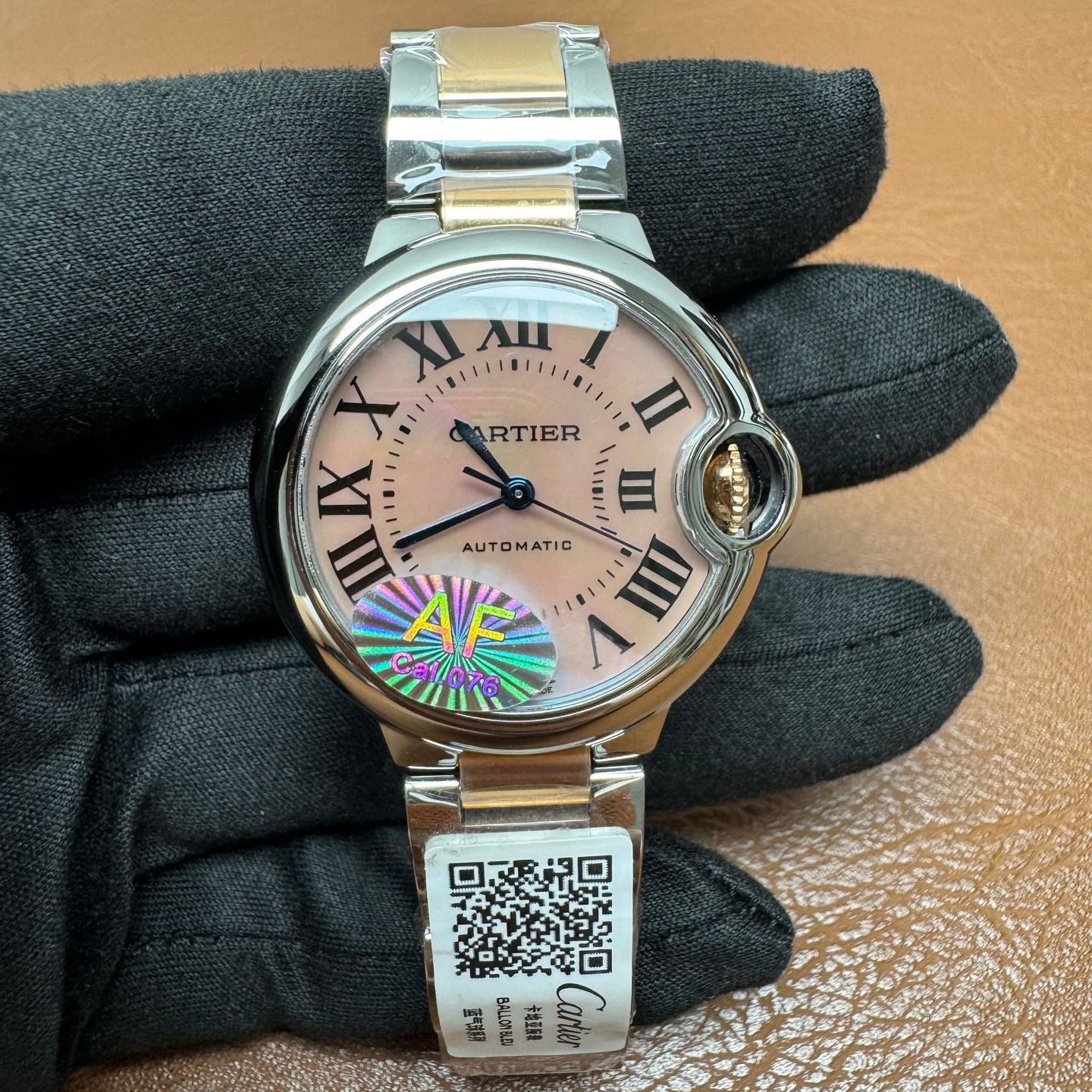 Cartier Ballon Bleu watch featuring a two-tone steel and gold bracelet and a distinctive pink dial