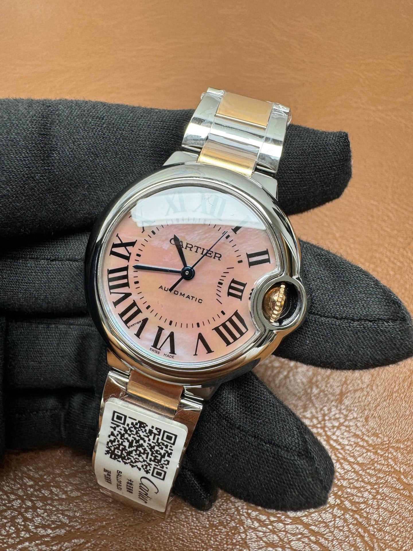 Cartier Ballon Bleu watch featuring a two-tone steel and gold bracelet and a distinctive pink dial