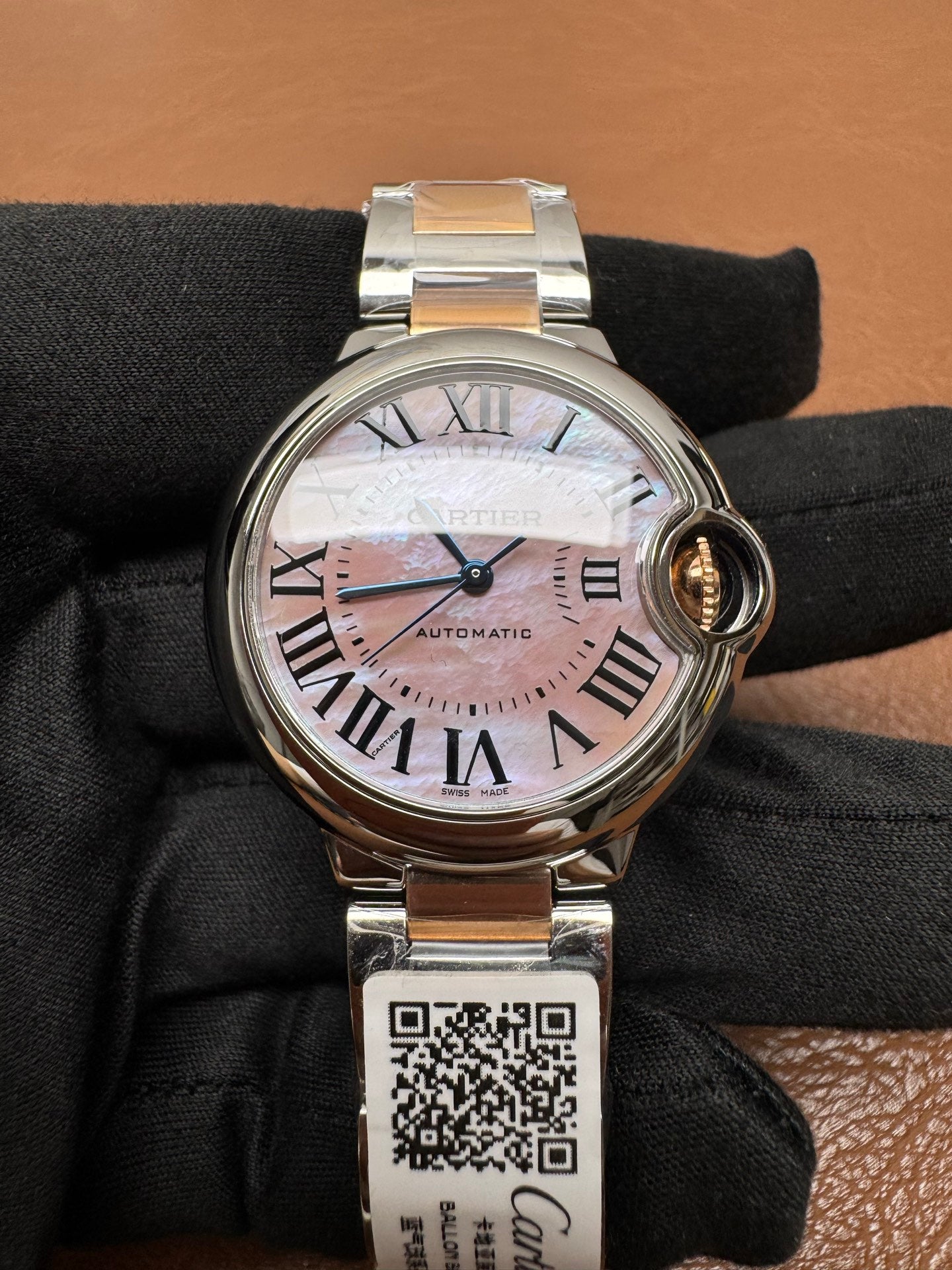 Cartier Ballon Bleu watch featuring a two-tone steel and gold bracelet and a distinctive pink dial