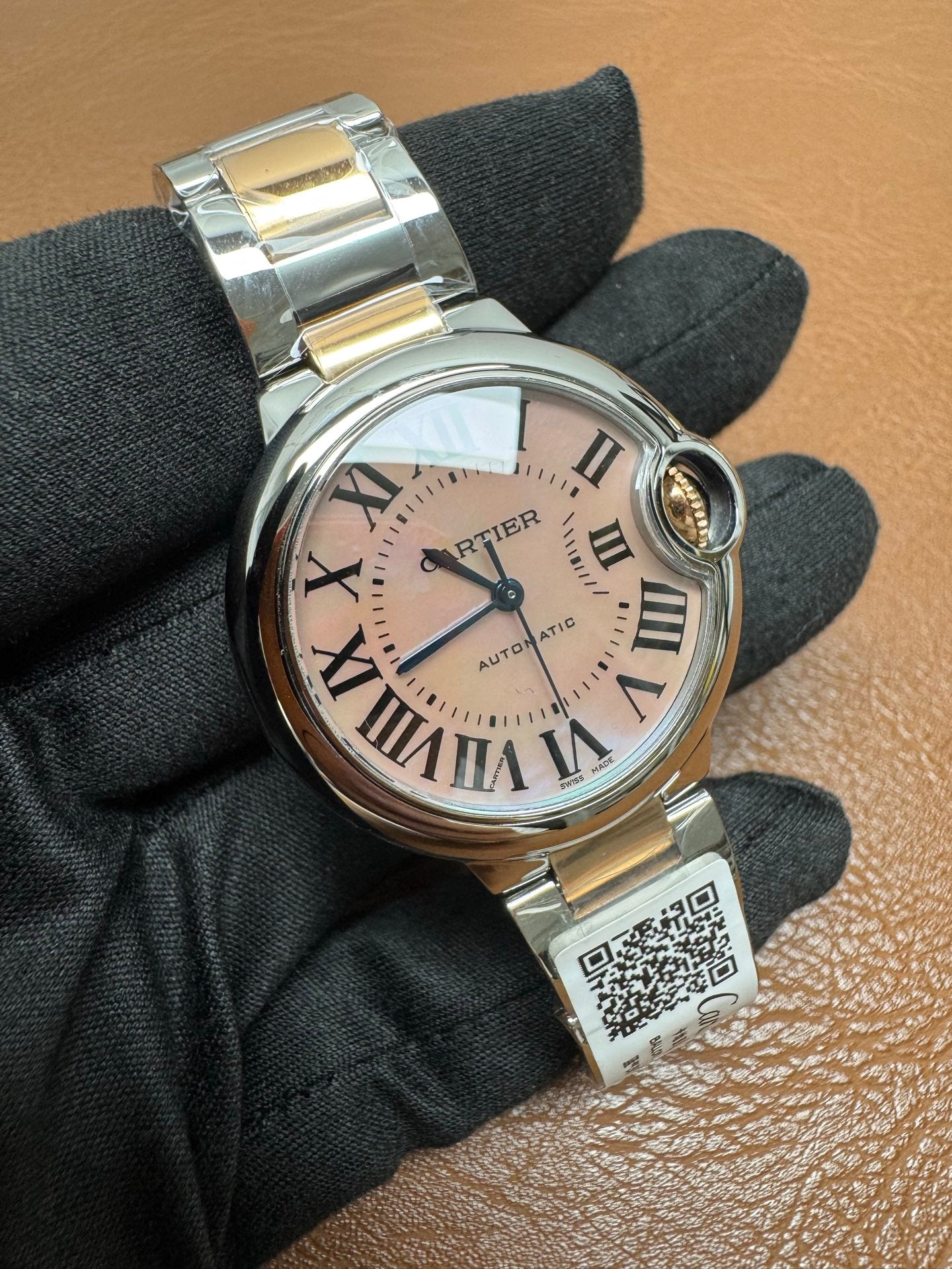 Cartier Ballon Bleu watch featuring a two-tone steel and gold bracelet and a distinctive pink dial